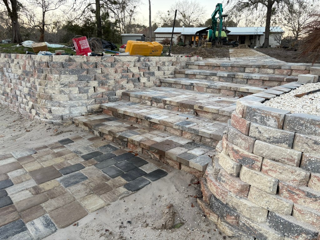 Paver installation showcasing a multi-level outdoor stairway and patio with textured stones, enhancing residential hardscaping in Jacksonville.